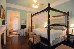 1 dormitorio con cama con dosel y chimenea en 1872 Denham Inn en Monticello