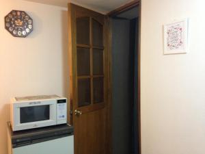 a door to a room with a microwave on a counter at Departamento en el corazón de Mendoza in Mendoza