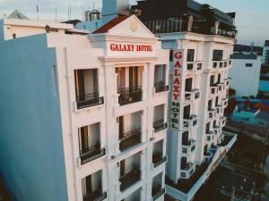 Ein hohes weißes Gebäude mit einem Schild drauf. in der Unterkunft Galaxy Hotel Phu Quoc in Phu Quoc