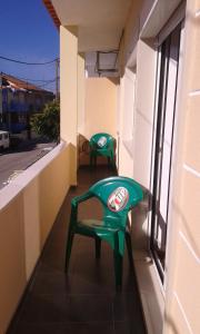 dwa zielone krzesła siedzące na balkonie budynku w obiekcie BEM ME QUER 1 w mieście Almada