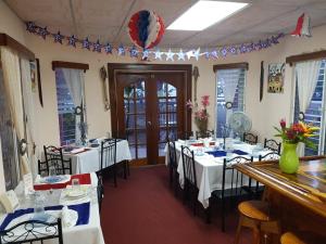 a dining room with white tables and chairs and flags at Beya Suites in Punta Gorda