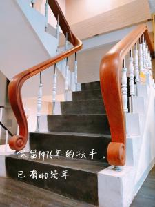 a staircase with a wooden handrail and a stair case at King Wow Inn in Tainan