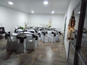 una habitación llena de mesas con manteles blancos en Casa En Gualeguaychu en Gualeguaychú
