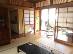 sala de estar con mesa y puertas de cristal en Kasumi-an, en Kumamoto