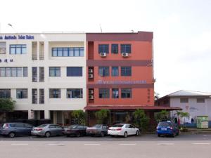 a building with cars parked in a parking lot at Lotus Hotel Johor Bahru in Johor Bahru