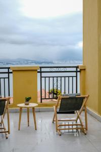 two chairs and a table on a balcony with a view at Dali lila's house Seaview Guesthouse in Dali