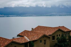 deux maisons au toit de tuiles rouges en face d'une montagne dans l'établissement Dali lila's house Seaview Guesthouse, à Dali