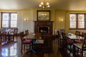 a dining room with tables and chairs and a fireplace at Palais Royale in Katoomba