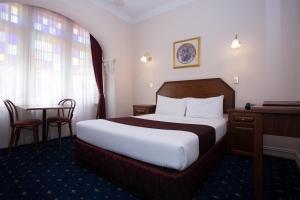 a hotel room with a bed and a table at Palais Royale in Katoomba