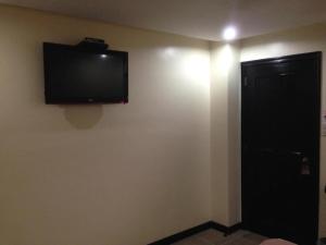 a flat screen tv on the wall of a room at Boomerang Hotel in Angeles