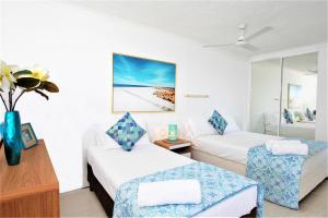 Habitación de hotel con 2 camas y mesa en Equinox Resort, en Gold Coast