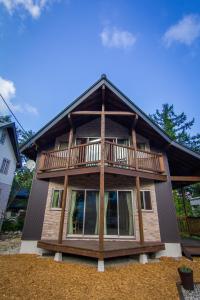 a large house with a balcony on top of it at Hakuba Powder Cottage in Hakuba