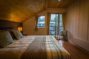 a bedroom with a large bed with a wooden ceiling at Hakuba Powder Cottage in Hakuba