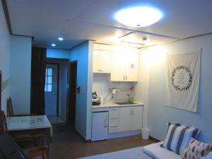 Mayfair Deneb Pension في بيونغتشانغ: مطبخ وغرفة معيشة مع أريكة وطاولة
