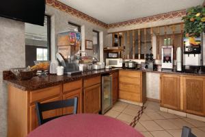 a large kitchen with wooden cabinets and appliances at Super 8 by Wyndham Cameron in Cameron