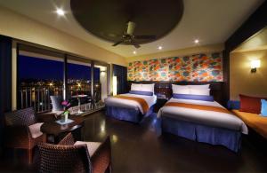 a hotel room with two beds and a balcony at Loisir Spa Tower Naha in Naha