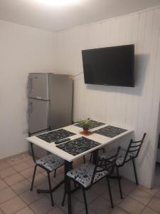 cocina con mesa, 2 sillas y nevera en Departamento ideal I! en Villa María