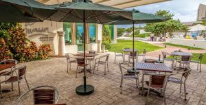 a patio with tables and chairs and an umbrella at Beachfront Getaway Condo in Cancún