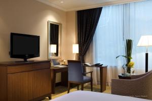 a hotel room with a television and a bed at Novotel Bangkok Suvarnabhumi Airport - SHA Extra Plus Certified in Lat Krabang