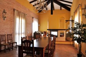 a dining room with a table and chairs and a fireplace at Casa Rural la Serrana in La Carlota