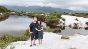 a man and a woman standing in front of a river at Minh Chau Beach Resort in Quang Ninh