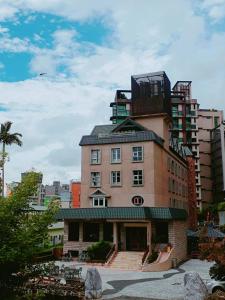 een groot bakstenen gebouw met een balkon erboven bij Hua Ge Hot Spring Hotel in Jiaoxi