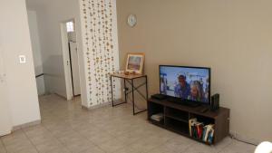 ein Wohnzimmer mit einem Flachbild-TV auf einem Stand in der Unterkunft San Martin 900 con estacionamiento in Cipolletti