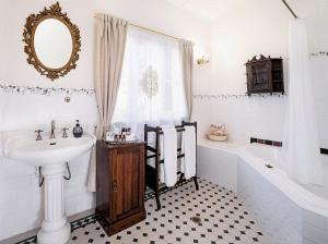 a white bathroom with a sink and a tub and a sink at Kurrara Historic Guest House in Katoomba