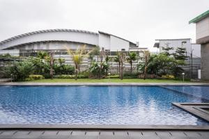 a swimming pool in front of a building at Novena Hotel Bandung in Bandung