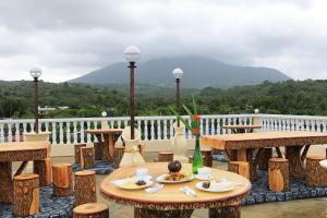 a patio with tables and chairs and a view of a mountain at Baletin Hometel in Basco