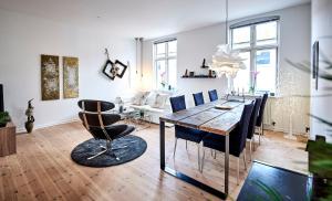 ein Wohnzimmer mit einem Holztisch und Stühlen in der Unterkunft Fredericia Apartment II in Fredericia