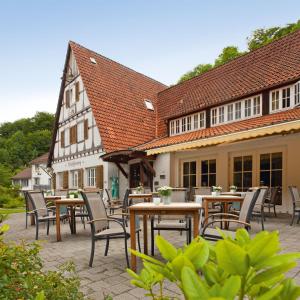 un patio con mesas y sillas frente a un edificio en Landhaus Hirschsprung, en Detmold