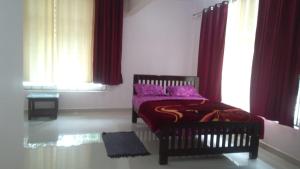 a bedroom with a bed with purple sheets and windows at Lake Trail Homestay Coorg in Madikeri