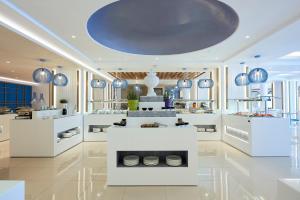 a kitchen with white counters and a blue ceiling at Mythos Palace Resort & Spa in Georgioupolis