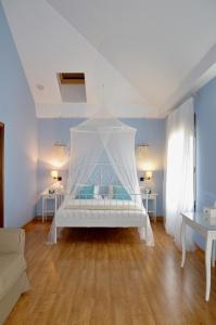 a bedroom with a bed with a white canopy at Casa Rural la Serrana in La Carlota