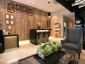 a lobby with a chair and a table with flowers at Kyoto Boutique Hotel in Johor Bahru