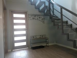 un escalier dans une pièce avec une porte et une fenêtre dans l'établissement Apartament Sunny Day, à Polanica-Zdrój 2 autres photos