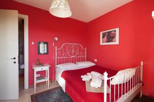サルザーナにあるChezcatherineの赤い壁のベッドルーム1室、ベッド1台(ベビーベッド付)