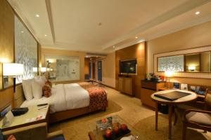 a large hotel room with a bed and a desk at Ramada Plaza Chennai in Chennai