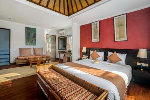 - une chambre avec un grand lit et un salon dans l'établissement Hartaning House by Pramana Villas, à Ubud