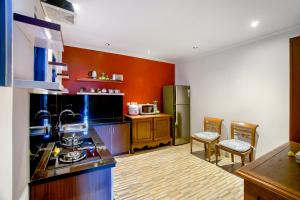 - une cuisine avec des murs orange et un comptoir dans l'établissement Hartaning House by Pramana Villas, à Ubud