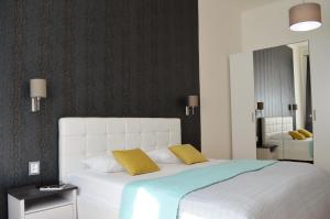 GE Apartments في براغ: غرفة نوم بسرير ابيض كبير مع مخدات صفراء