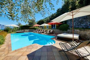 einen Pool mit Stühlen und Sonnenschirmen im Hof in der Unterkunft Residence Mariù in Malcesine