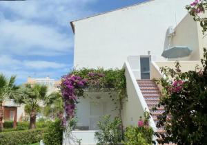 a white building with flowers on the side of it at Duplex Naturista urb. Vera Natura in Vera