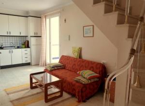 維拉的住宿－Duplex Naturista urb. Vera Natura，客厅配有红色的沙发和桌子
