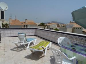 a patio with two chairs and a table on a roof at Duplex Naturista urb. Vera Natura in Vera
