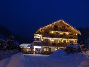 a large building covered in snow at night at Les Chalets de La Griyotire in Praz-sur-Arly