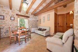 uma sala de estar com uma mesa e um sofá em Casa De Piedra em Campanet