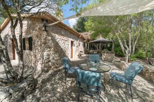 a patio with a table and chairs in front of a stone building at Casa De Piedra in Campanet