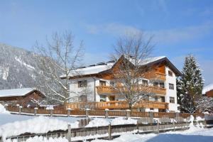 a building with a fence in the snow at Ferienwohnung Dreer in Hofen